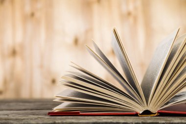 Tahta bir masanın üzerinde açık bir kitap  