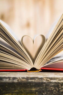 Tahta bir masanın üzerinde açık bir kitap  