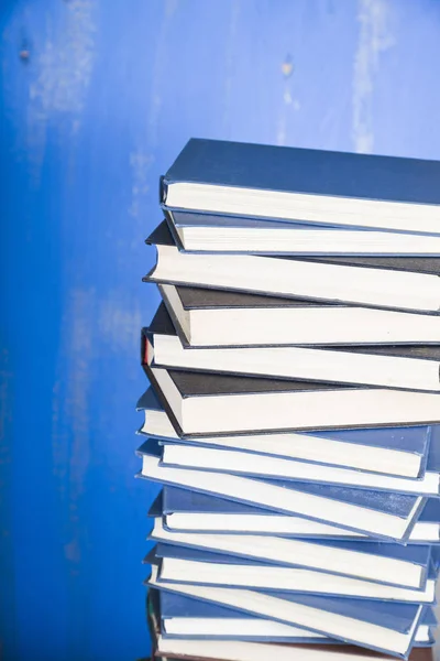 Pila de libros sobre un fondo azul. — Foto de Stock