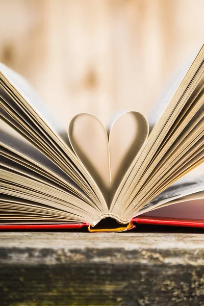 Tahta bir masanın üzerinde açık bir kitap  