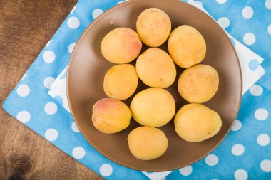 Ahşap bir masada kayısılar.  