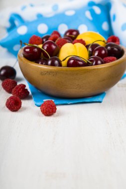 Ahşap bir masa üzerinde bir tabak içinde olgun çilek.  