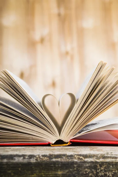 Tahta bir masanın üzerinde açık bir kitap  