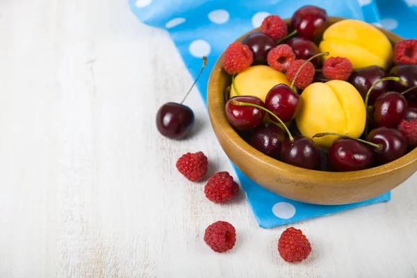 Ahşap bir masa üzerinde bir tabak içinde olgun çilek.  