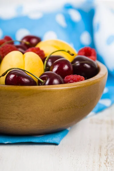 Ahşap bir masa üzerinde bir tabak içinde olgun çilek.  