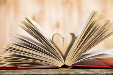 Tahta bir masanın üzerinde açık bir kitap  