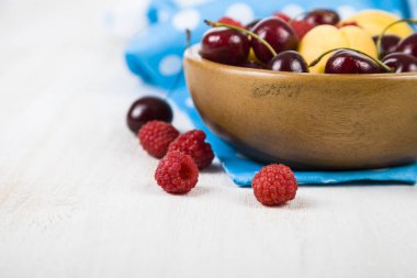 Ahşap bir masa üzerinde bir tabak içinde olgun çilek.  