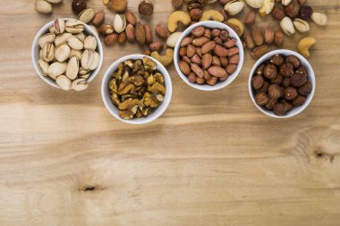 Ahşap bir masa üzerinde fındık ile dört kase. 