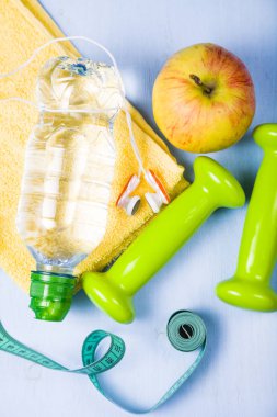 Halter, bir elma, bir havlu ve bir şişe su 