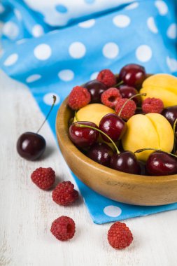 Ahşap bir masa üzerinde bir tabak içinde olgun çilek.  