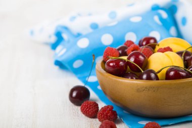 Ahşap bir masa üzerinde bir tabak içinde olgun çilek.  