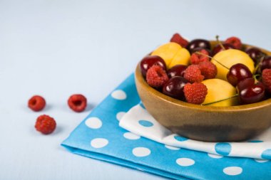 Ahşap bir masa üzerinde bir tabak içinde olgun çilek. 