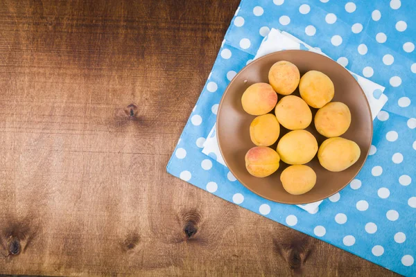 Ahşap bir masada kayısılar.  