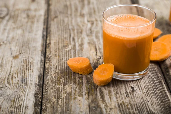 havuç suyu ahşap bir masa üzerinde.