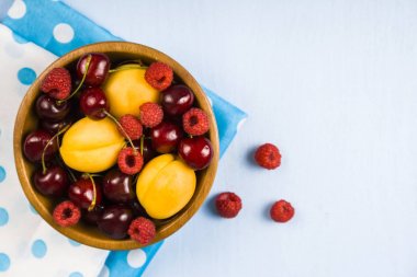 Ahşap bir masa üzerinde bir tabak içinde olgun çilek.  