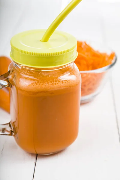 Suco de cenoura em uma mesa de madeira . — Fotografia de Stock