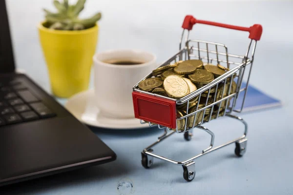 Carrello della spesa con monete e laptop — Foto Stock