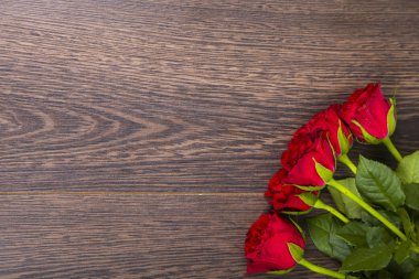 Ahşap arka planda kırmızı güller.