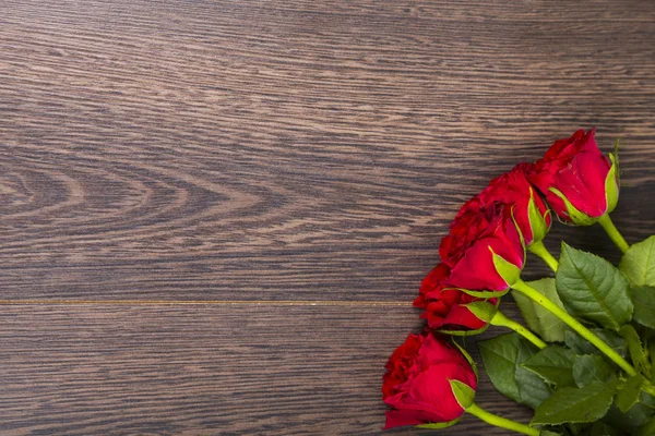 Ahşap arka planda kırmızı güller.