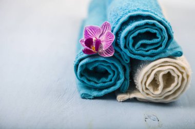 Beyaz ve mavi havlu ve bir orkide çiçeği.