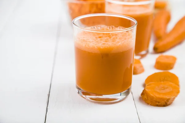 Морковный сок на деревянном столе . — стоковое фото