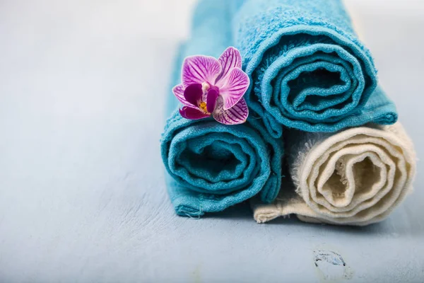 Beyaz ve mavi havlu ve bir orkide çiçeği.