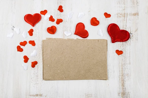Rode en witte hartjes op een houten achtergrond. — Stockfoto