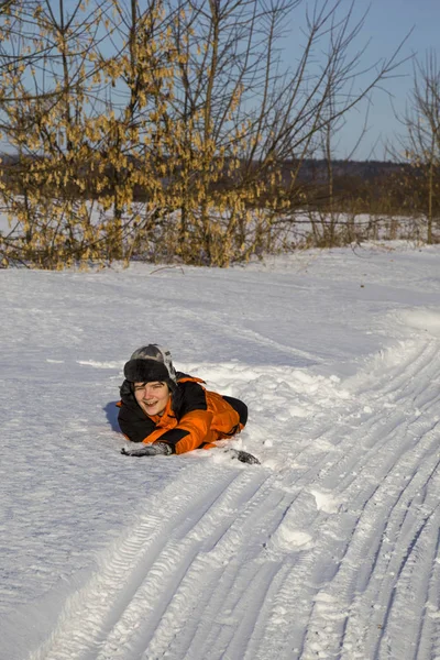 Lycklig pojke ligger i en snödriva. — Stockfoto