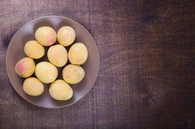 Ahşap bir masada kayısılar.