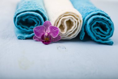 Beyaz ve mavi havlu ve bir orkide çiçeği.