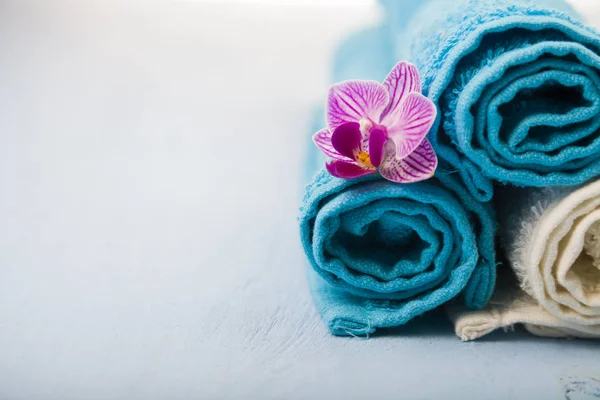 Vit och blå handdukar och en orkidé blomma. — Stockfoto
