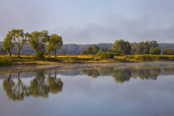 Lago no início da manhã com um nevoeiro . — Fotografia de Stock