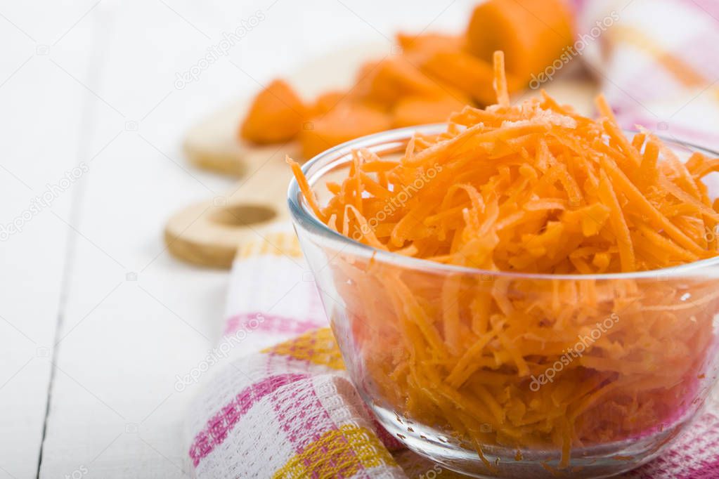 Grate  carrots in a bowl  