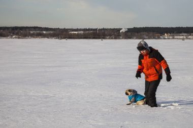 Oğlan ve köpek kış aylarında yürüyen
