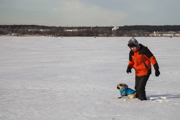 Oğlan ve köpek kış aylarında yürüyen