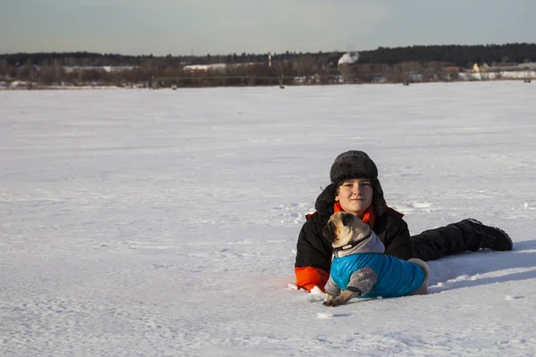 Pojke och hund promenader i vinter — Stockfoto