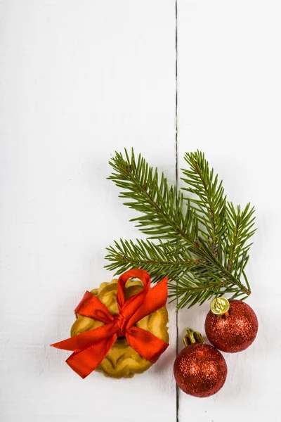 Kerst cookie met een rode strik, vuren tak en ballen — Stockfoto