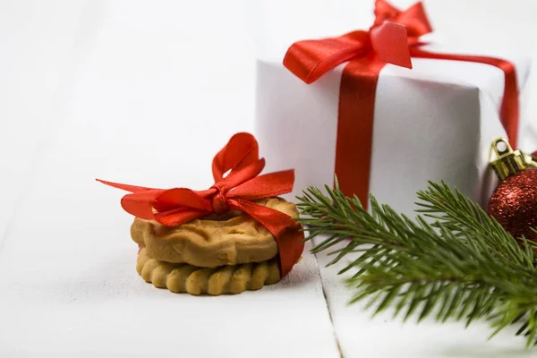 Biscoitos de Natal e uma caixa com um arco vermelho . — Fotografia de Stock