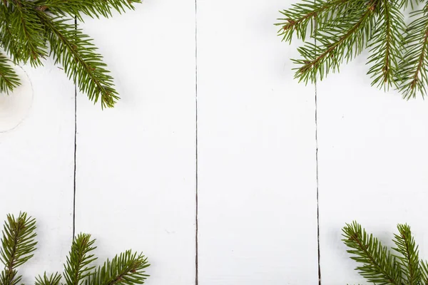 Beyaz ahşap zemin üzerinde çam dalları.