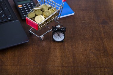 Paralar, dizüstü bilgisayar ve çalar saat ile alışveriş arabası