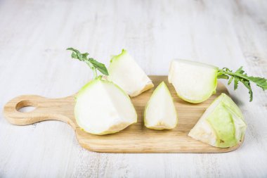 Ahşap bir masa üzerinde kesme tahtası üzerinde kıyılmış sarımsak 