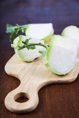 Ahşap bir masa üzerinde kesme tahtası üzerinde kıyılmış sarımsak 