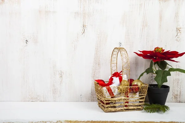 Cesto d'oro con regali di Natale e poinsettia — Foto Stock