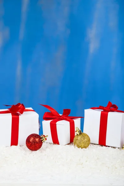 Regalos con lazos rojos en la nieve —  Fotos de Stock