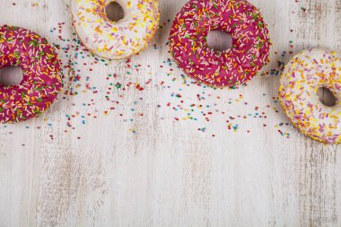 Ahşap arka plan üzerinde renkli donut. 