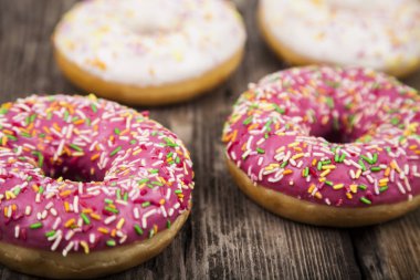 Ahşap arka plan üzerinde renkli donut. 