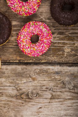 Ahşap arka plan üzerinde renkli donut. 