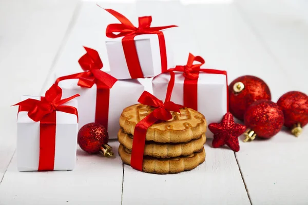 Christmas cookie, spruce branch, gift and balls. — Stock Photo, Image