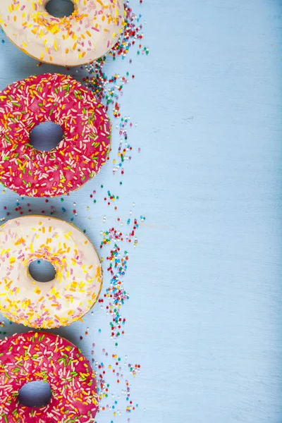 Ahşap arka plan üzerinde renkli donut. 