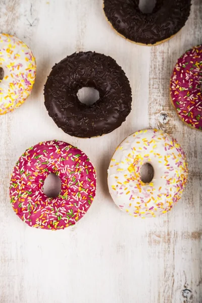 Ahşap arka plan üzerinde renkli donut. 